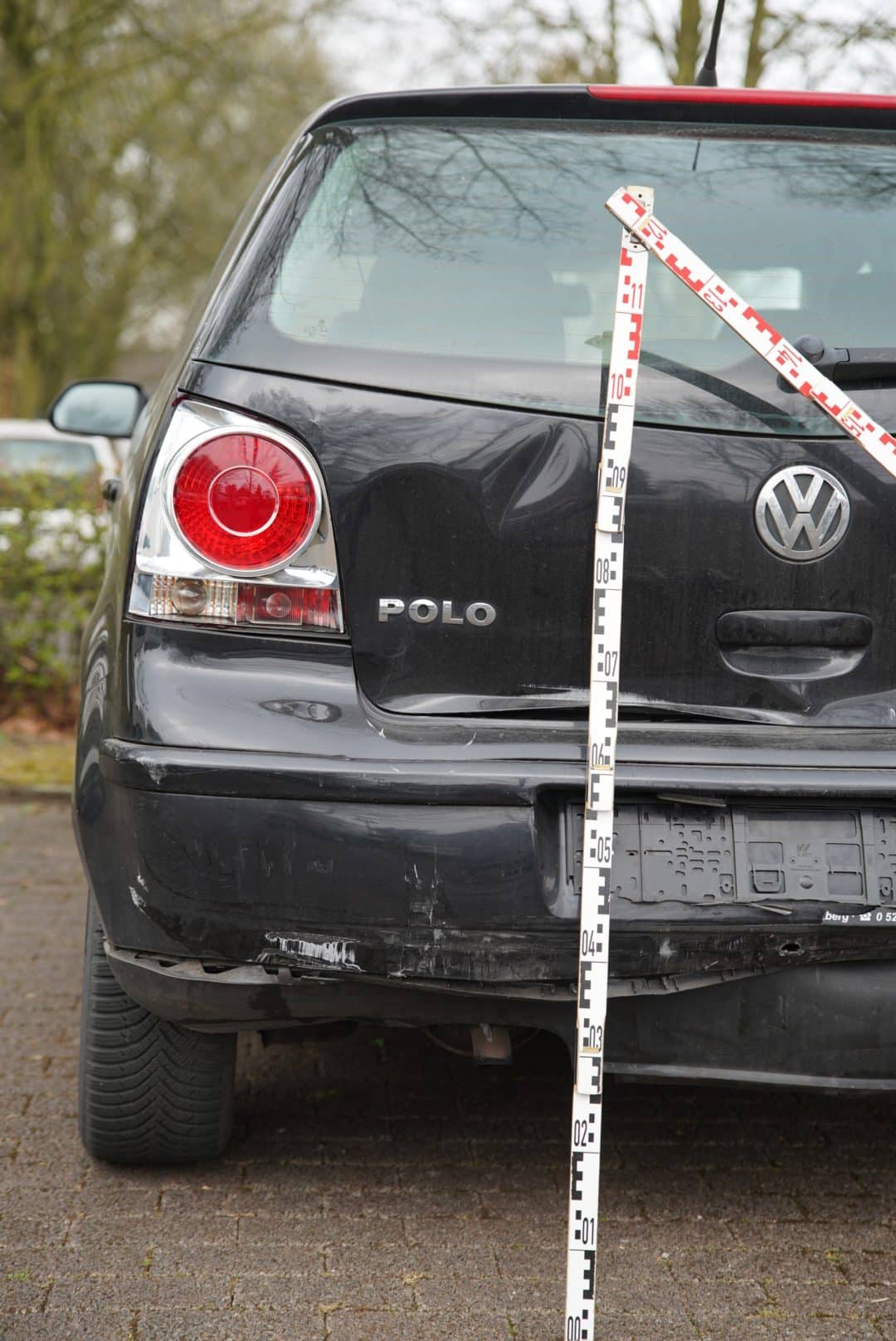 Delle in der Heckklappe nach einem Auffahrunfall, mit Messlatte dokumentiert