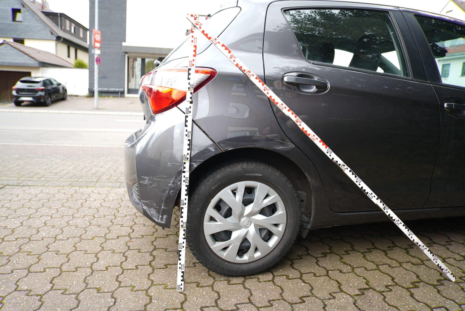Streifschaden an Heckstoßfänger und Seitenwand, mit Messlatte vermessen